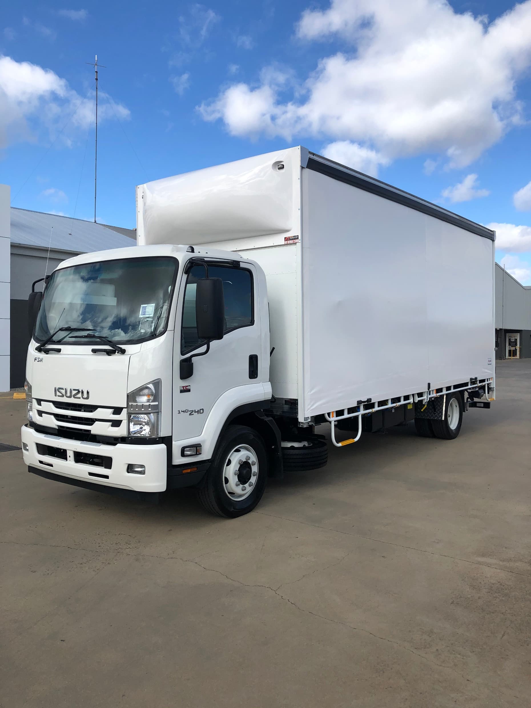 White Isuzu FSR 140-240 delivery truck with a large white curtain-side body parked outdoors.